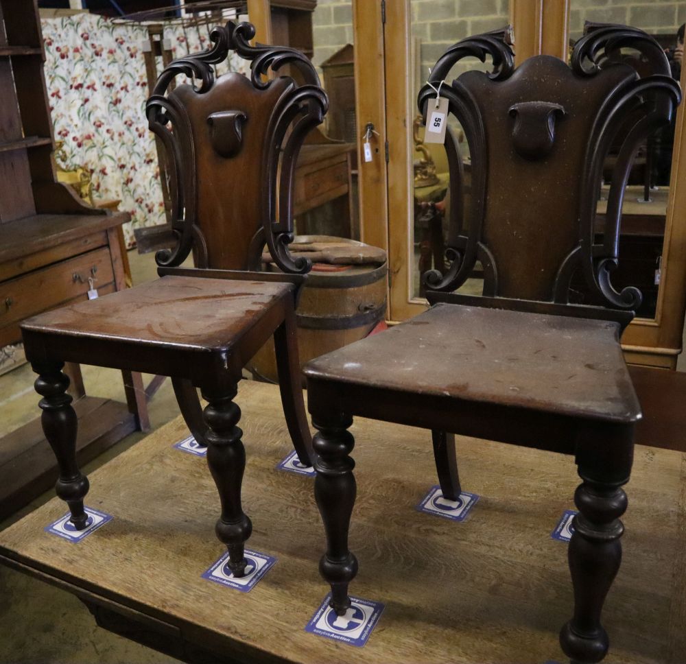 A pair of Victorian mahogany hall chairs (one a.f.)
